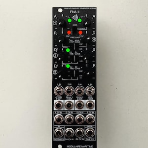 May include: Black modular synthesizer module with the text "ENA II" and various knobs, buttons, and ports. The module has green and red LED lights and the text "MODULAIRE MARITIME" at the bottom.