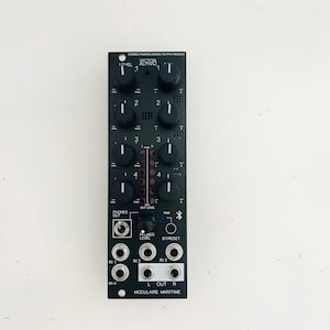May include: Black electronic module with knobs and input/output jacks. The module has the text "VICTOR ALPHA 2" and "MODULAIRE MARITIME". It features multiple level controls and input/output ports for audio signal processing.