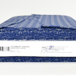 May include: A roll of blue fabric with a white bandana print. The label reads "Sevenberry Bandana SB-4219201-3 Blue".