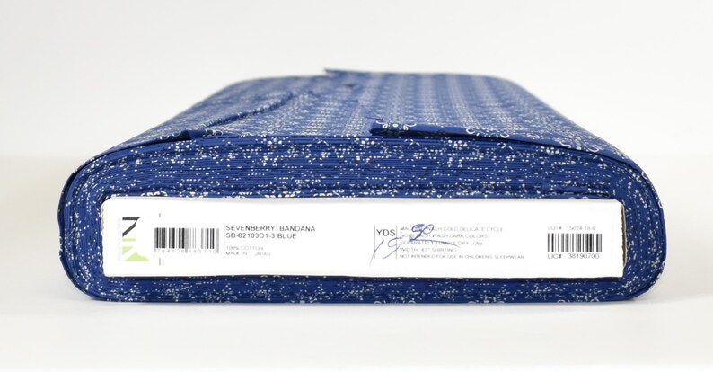 May include: A roll of blue fabric with a white bandana print. The label reads "Sevenberry Bandana SB-4219201-3 Blue".