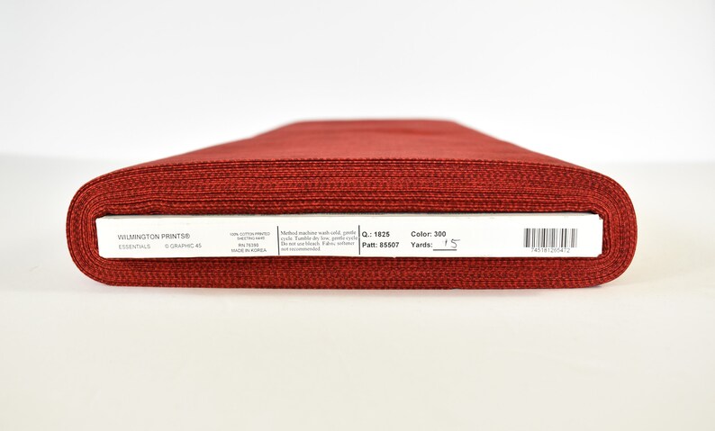 May include: A roll of red fabric labeled "Wilmington Prints" Essentials, with the details "Color: 300", "Yards: 1.5", "Patt: 85507", and "MQ: 1825".
