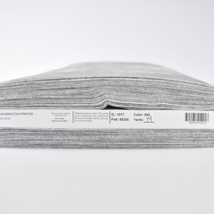May include: A roll of gray fabric labeled "WILMINGTON PRINTS&reg; Dry Brush" with the details "Q: 1077 Patt: 89205 Color: 909 Yards: 1 1/4"