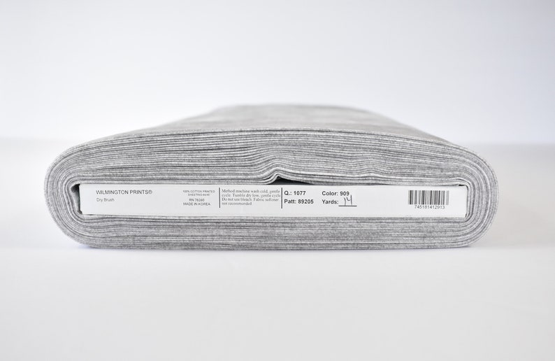 May include: A roll of gray fabric labeled "WILMINGTON PRINTS&reg; Dry Brush" with the details "Q: 1077 Patt: 89205 Color: 909 Yards: 1 1/4"