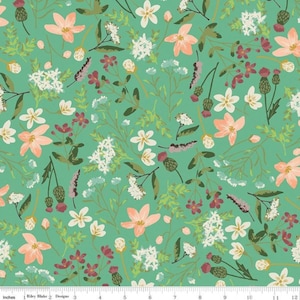 May include: A teal fabric with a repeating pattern of white, pink, and green flowers. The fabric has a ruler printed on the bottom edge.
