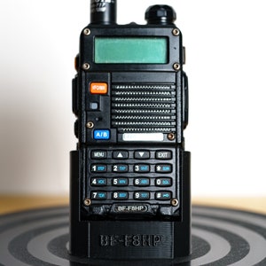 May include: A black two-way radio with a digital display and a keypad. The radio is in a charging cradle with the text "BF-F8HP" printed on it.