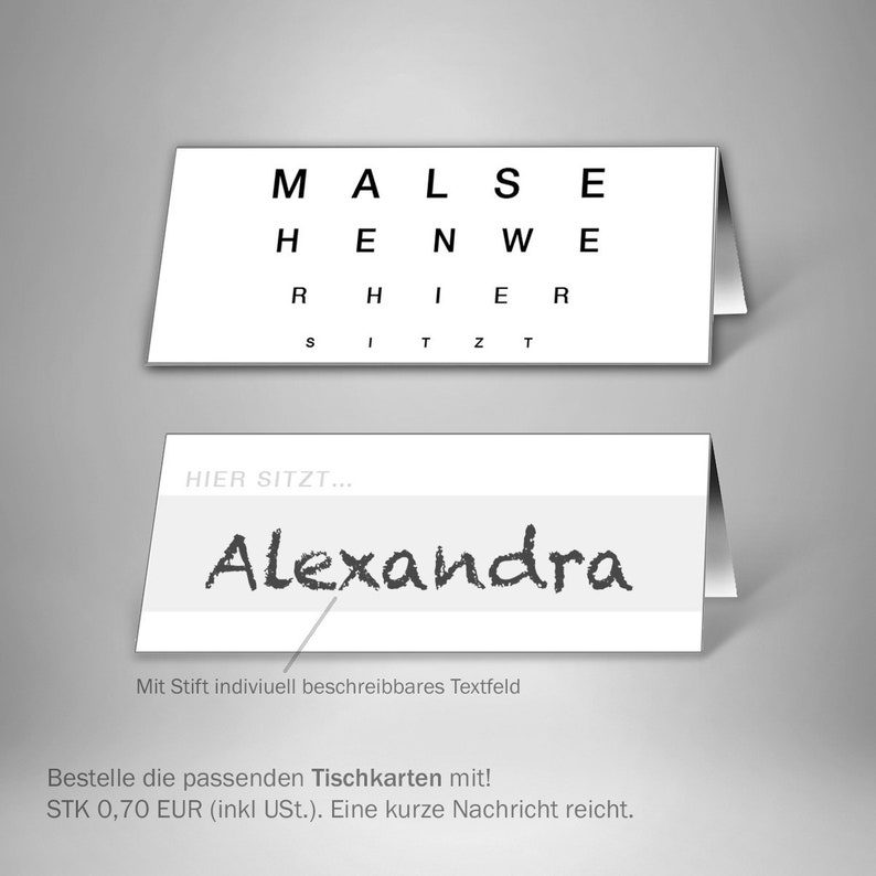 May include: White place card with black text that reads "MALS E HEN WE R H I E R S I T Z T" and "HIER SITZT..." followed by the name "Alexandra" written in black marker. The text "Mit Stift individuell beschreibbares Textfeld" appears below the name. The text "Bestelle die passenden Tischkarten mit! STK 0,70 EUR (inkl USt.). Eine kurze Nachricht reicht." appears at the bottom of the card.