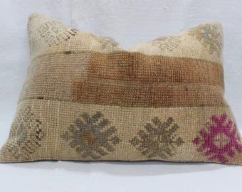 May include: Rectangular beige pillow with brown and tan stripes and floral patterns. The pillow has a woven texture and a decorative design with pink and gray accents. A home decor item.