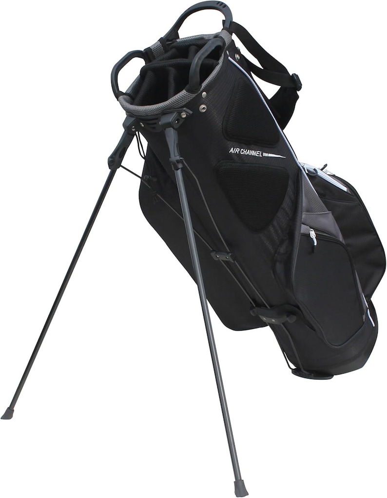 May include: Black golf bag with a stand. The bag has multiple compartments and a handle at the top. The text "AIR CHANNEL" is printed on the side. The stand legs are extended, ready for use.