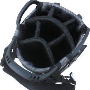 May include: A black and gray golf bag with multiple compartments for clubs. The bag has a sturdy handle and a shoulder strap for easy carrying. The interior is divided into sections to keep clubs organized.