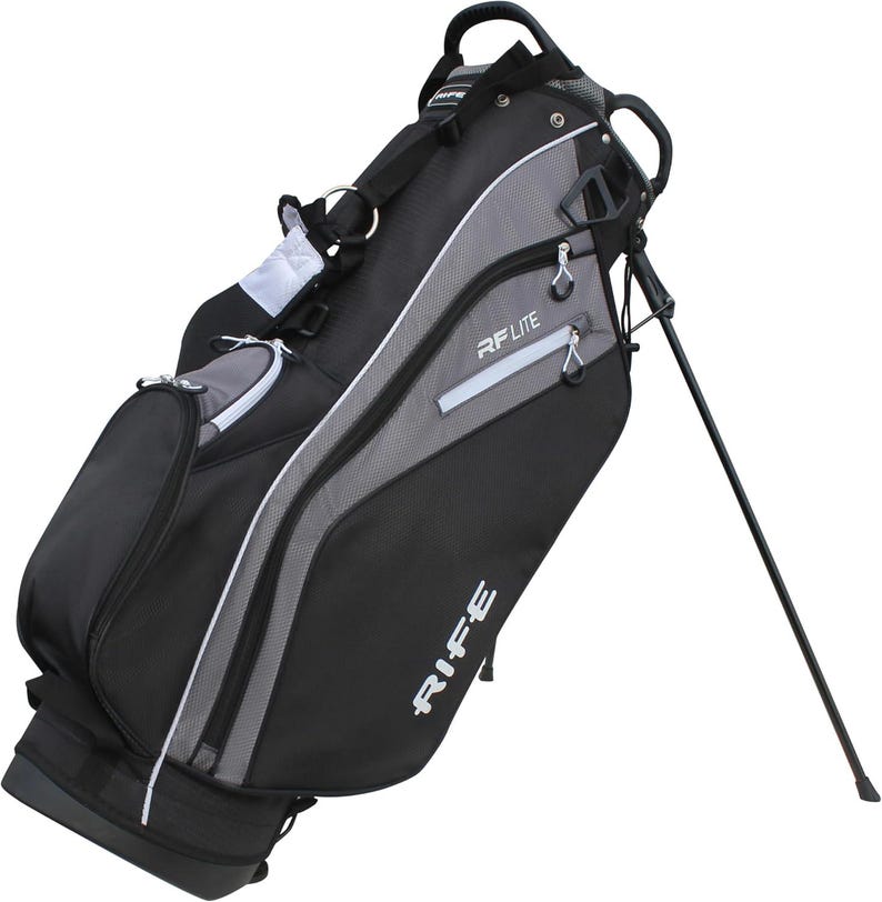 May include: Black and gray golf bag with the text "RIFE" and "RF LITE" in white. The bag has a stand, multiple zippered compartments, and a shoulder strap. The bag is angled, showing its side profile.