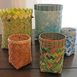 May include: Five woven baskets of different sizes and colours. The baskets are made of natural materials and have a variety of patterns.
