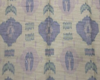 Puede incluir: Primer plano de una tela beige con un patrón repetitivo de formas geométricas moradas, rosas y verdes. La tela tiene una textura sutil y un brillo ligeramente iridiscente.