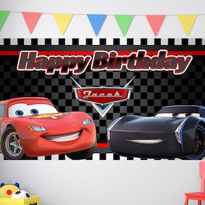 May include: A black and white checkered background with the words "Happy Birthday" in red. The name "Jacob" is in red on a red and silver car logo. A red car with a smiling face and a black car with a smiling face are on either side of the logo.