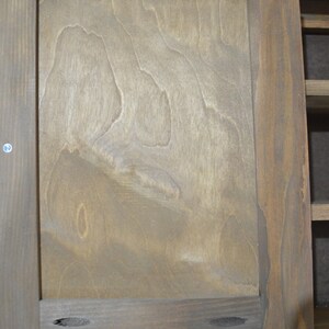 Puede incluir: Una puerta de armario de madera con un acabado de grano de madera marr&oacute;n claro. La puerta tiene un dise&ntilde;o simple con un marco y un solo panel. La puerta est&aacute; cerrada y tiene algunos peque&ntilde;os agujeros en el marco.
