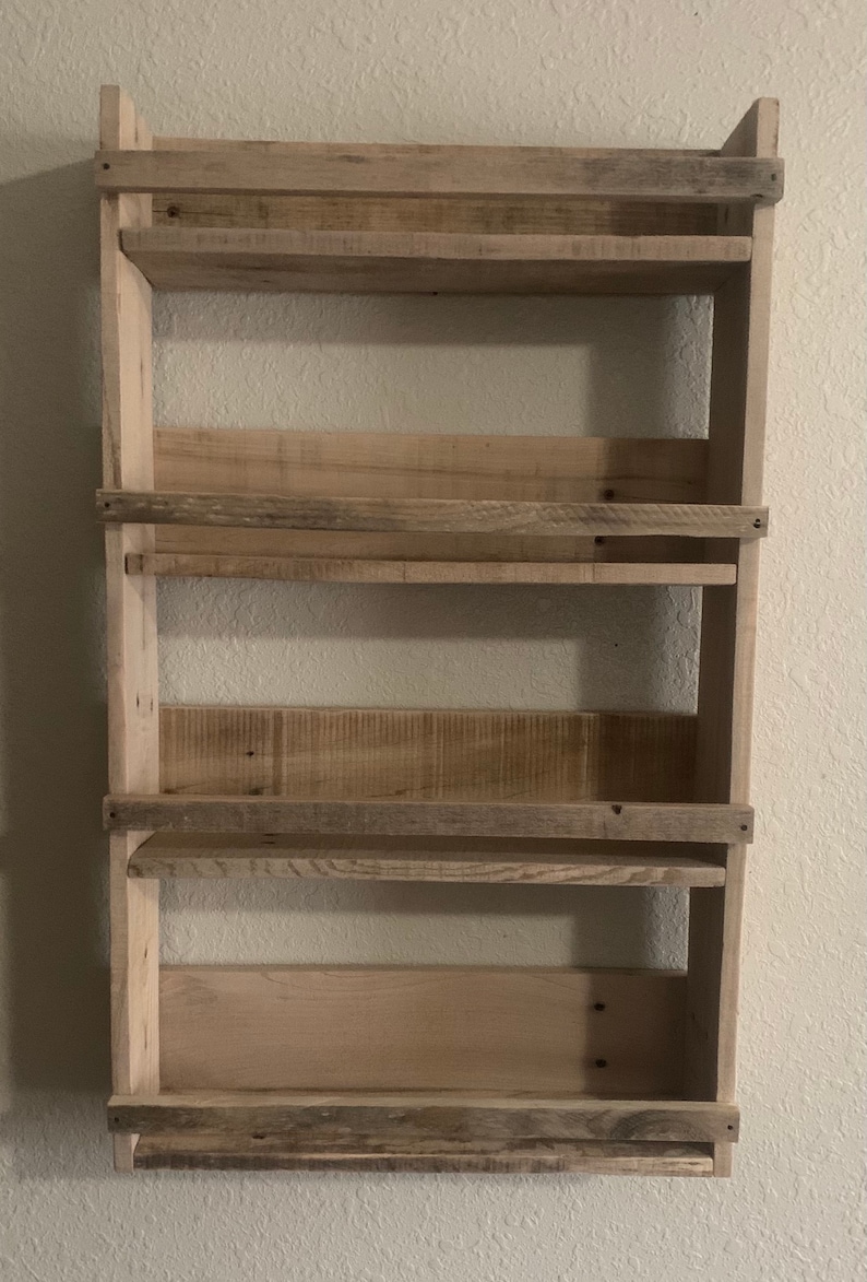 May include: A rustic wooden shelf unit with four shelves. The shelves are made of reclaimed wood and have a natural, weathered finish.