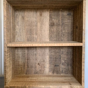 May include: A wooden bookshelf with two shelves. The shelves are made of reclaimed wood and have a rustic look. The bookshelf is empty.