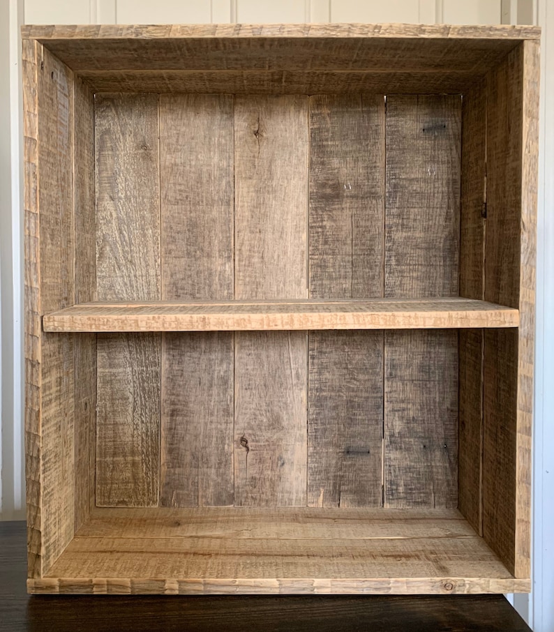 May include: A wooden bookshelf with two shelves. The shelves are made of reclaimed wood and have a rustic look. The bookshelf is empty.