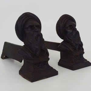 Large pair of cast iron fireplace andirons with Tuareg heads. France, 19th century.