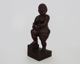 Grotesque exotic wood sculpture of a woman showing her thigh. 80s. Botero style