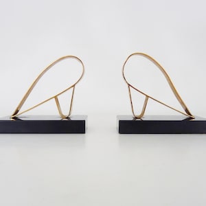 Pair of Modernist Art Deco Gold Starry bookends on a black marble base.
