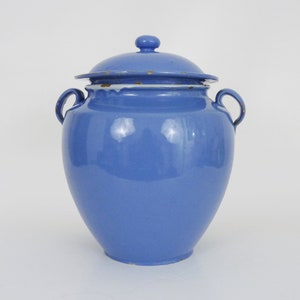 May include: A blue ceramic jar with a lid and two handles. The jar has a rounded body and a slightly flared top.