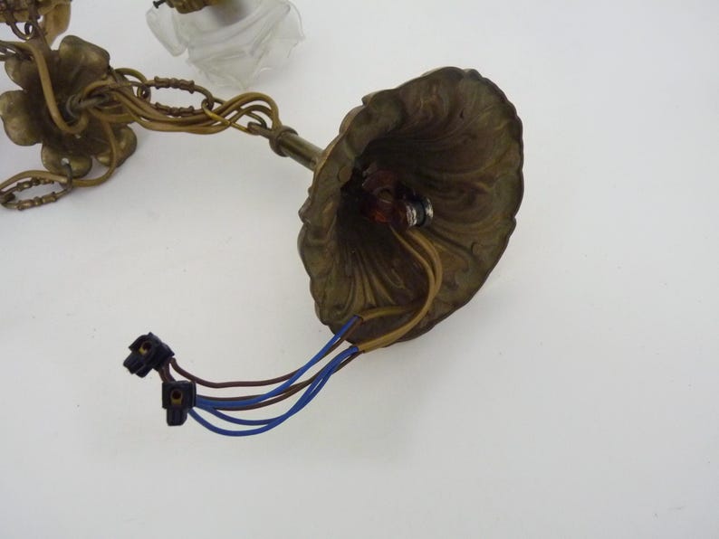 Puede incluir: Luminaria de ara&ntilde;a de lat&oacute;n antiguo con detalles florales y de hojas. La luminaria tiene una capota decorativa, cableado y una cadena para colgar. Los cables son azules y marrones. Dise&ntilde;ado para una l&aacute;mpara de techo.