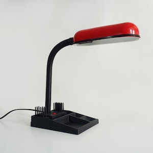 Old red and black flexible desk lamp with pencil holder