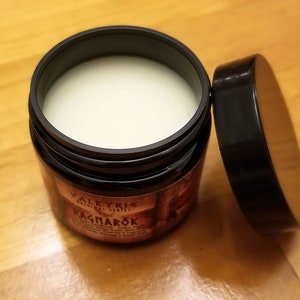 Puede incluir: Un tarro negro con una etiqueta blanca que dice "Valkyrie Original Series Ragnar&ouml;k". El tarro est&aacute; abierto y contiene una crema blanca.