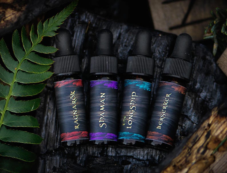 May include: Four small glass bottles with dropper tops, each with a different colored label and text. The labels read "Ragnarok", "SidaMan", "The LongShip", and "Berserker".