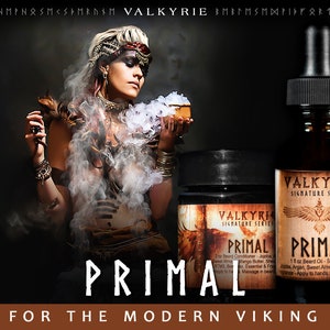 Pu&ograve; includere: Una donna con un'espressione feroce tiene una piccola scatola di legno con una sostanza bianca al suo interno. Lo sfondo &egrave; scuro e fumoso. L'immagine presenta anche due bottiglie di olio per barba con il testo "Valkyrie Signature Series Primal" sulle etichette. Il testo "For the Modern Viking" &egrave; nella parte inferiore dell'immagine.