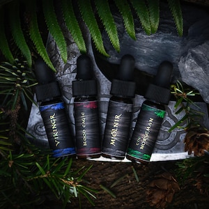 May include: Four small black bottles with gold lettering and different colored liquids. The bottles are labeled "Viking", "Blood Eagle", "Mjolnir", and "The Norsemen".