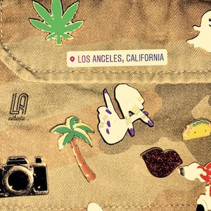May include: A brown camouflage jacket with various pins, including a palm tree, a camera, a ghost, a taco, a red bow, a glitter lip, and a pin that says "LA" with a location pin and the text "Los Angeles, California".
