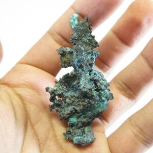 May include: A large, irregularly shaped piece of copper ore with a green and blue patina. The ore is rough and textured, with a variety of shapes and sizes.