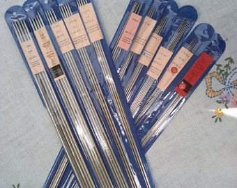 May include: A set of 10 pairs of silver knitting needles in various sizes, packaged in clear plastic with blue backing. The needles are labeled with their size in millimeters and UK size.