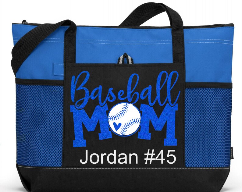 May include: Blue and black tote bag with a mesh pocket. The bag has a white design that says "Baseball Mom" with a baseball and heart graphic. The text "Jordan #45" is also included in the design.