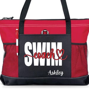 May include: Red and black tote bag with the words "SWIM coach" in white and red script, and the name "Ashley" in white script. The bag has black handles, a zippered top, and mesh side pockets. A red pen is in the side pocket.