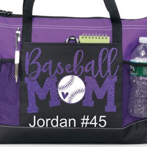 May include: Purple and black tote bag with a zipper closure and mesh side pockets. The bag has a design that says "Baseball Mom" with a baseball and a heart. The name "Jordan #45" is printed below the design.