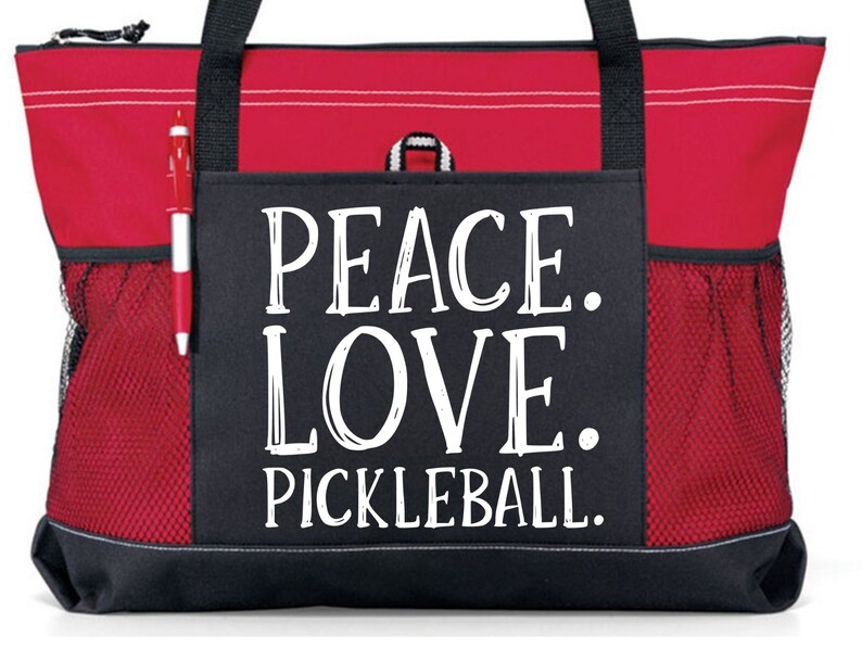 May include: Red and black tote bag with a large white graphic that says "Peace. Love. Pickleball."