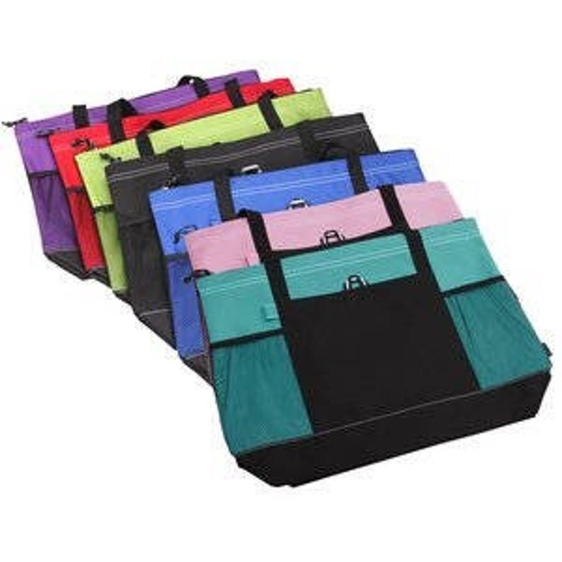 May include: A collection of colorful tote bags in various shades, including purple, red, green, black, blue, pink, and teal. Each bag features a main compartment, side pockets, and sturdy handles for carrying.