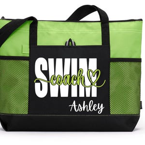 May include: A lime green and black tote bag with the words "SWIM coach" in white and green script, with the name "Ashley" below. The bag has black handles, a black base, and mesh side pockets.