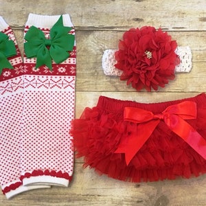 May include: Red and white knit leg warmers with green bows, a red tulle tutu with a red satin bow, and a red flower headband with a white crocheted band.