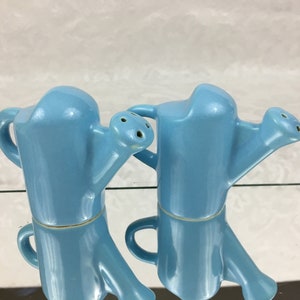 May include: A pair of blue ceramic salt and pepper shakers shaped like watering cans.