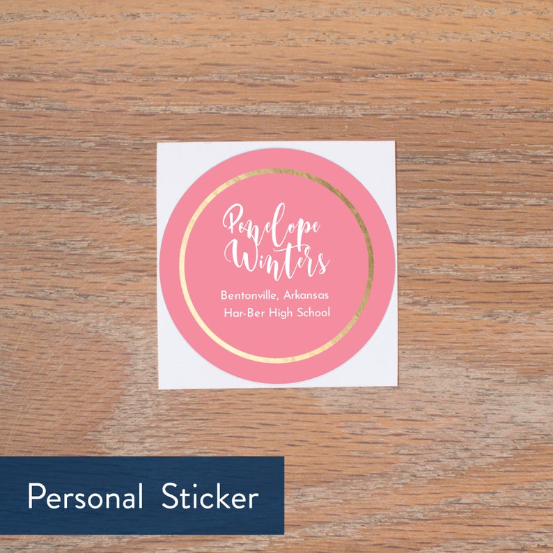 May include: Pink round sticker with a gold circle border. The text "Pandope Winters" is in white cursive font. The text "Bentonville, Arkansas Har-Ber High School" is in white font.