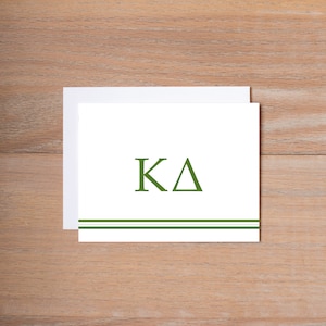 May include: A white card with green double lines at the bottom and the letters "KA" in green.
