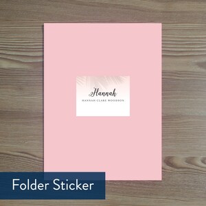 May include: Pink folder sticker with a palm leaf design and the text "Hannah Hannah Clare Woodson".