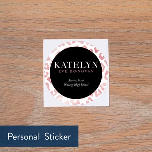 May include: A round, white sticker with a black circle in the center. The black circle has the text "KATELYN EVE DONOVAN" in white, followed by "Austin, Texas Waverly High School" in smaller white text. The sticker has a pink leopard print pattern.
