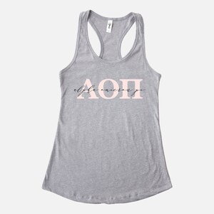 May include: Gray tank top with a pink "Alpha Omicron Pi" design.