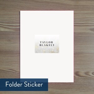 K&ouml;nnte beinhalten: Wei&szlig;er Ordnerrkleber mit Marmorhintergrund und goldenen Akzenten. Der Text "TAYLOR BLAKELY" ist in Schwarz gedruckt.