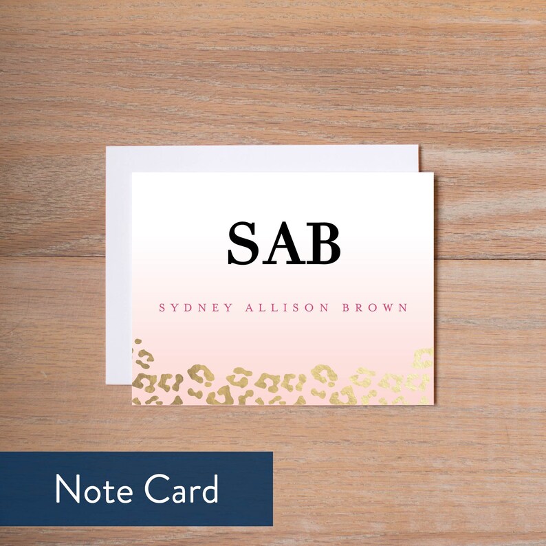 May include: A pink and white note card with gold leopard print at the bottom. The card has the text "SAB" in black and "SYDNEY ALLISON BROWN" in pink.