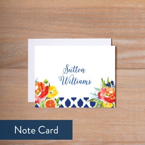 May include: A white note card with a blue and white patterned border. The card features a watercolor illustration of orange blossoms, lemons, and blue flowers. The text "Sutton Williams" is printed in blue cursive script.